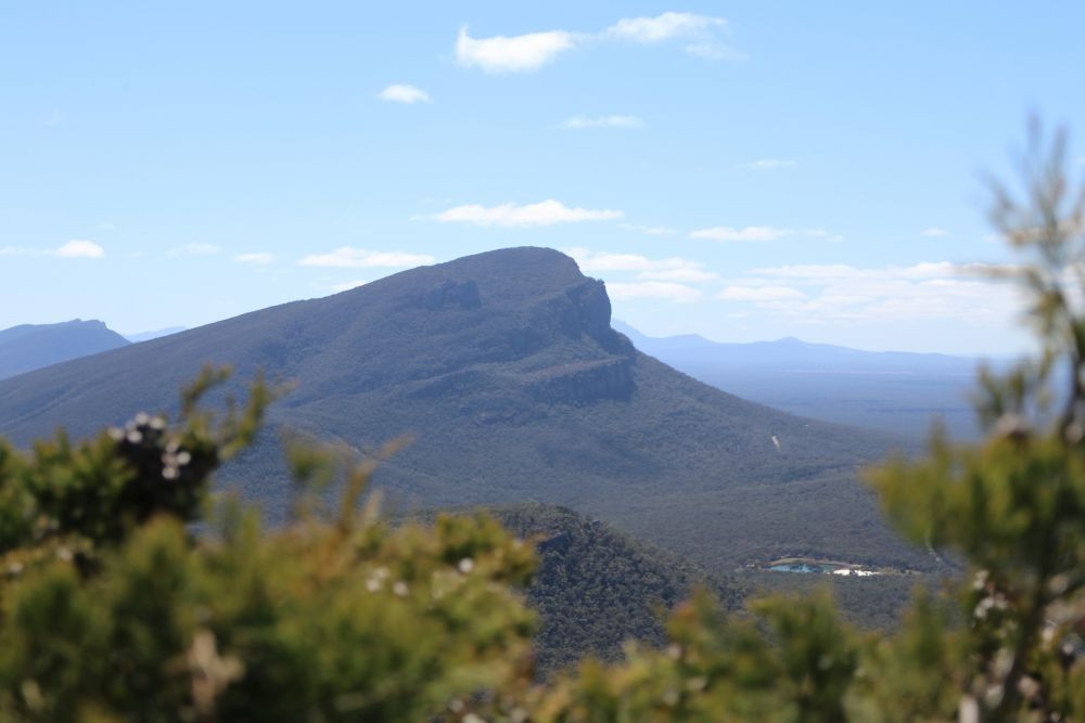 a-view-of-a-mountain-range-with-trees-in-the-foreground-christian-bass-c1harjtjgfk-unsplash.jpg